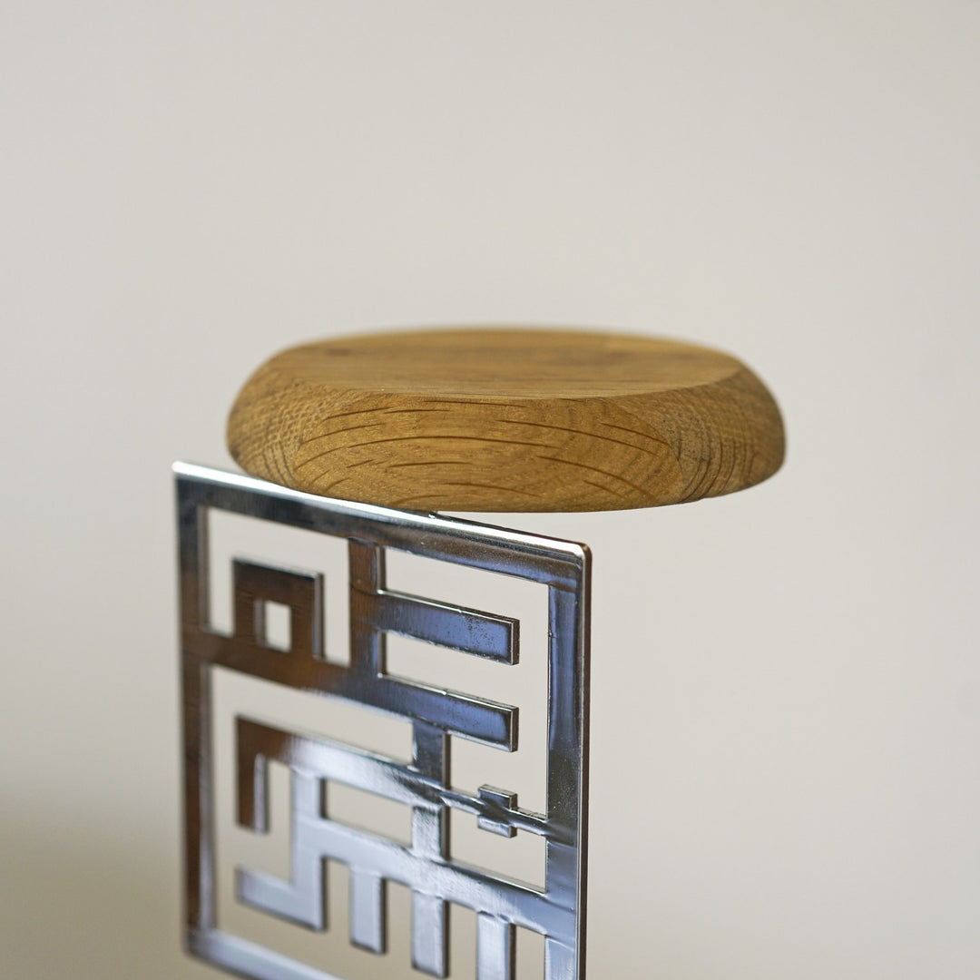 Nahaufnahme der Eichenscheibe oben und des glänzend silbernen Kufi-Ausschnitts, der den Raum spiegelt
