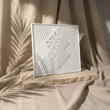 Carreau coufique en relief verset 1 de la Fatihah, vue de face avec écriture en relief sur lignes courbes