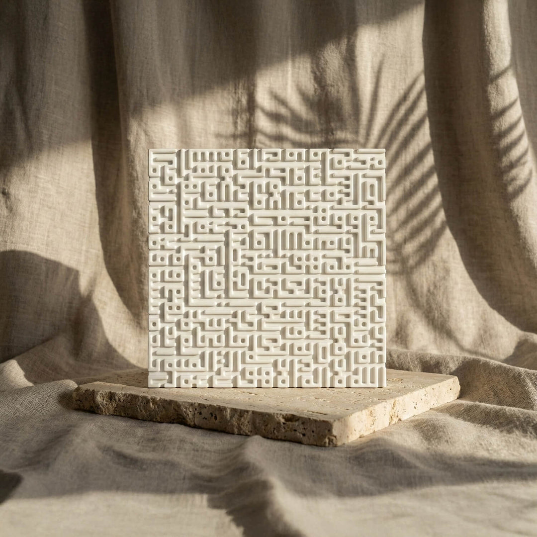 Kufic stone relief tile in white cast stone, front view with palm leaf shadows on linen