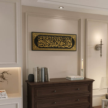 Gold acrylic La hawla wa la quwwata illa billah glass wall art above a wooden chest of drawers