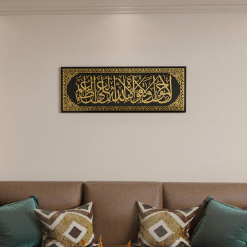 La hawla wa la quwwata illa billah glass wall art in gold acrylic on black, hung above a brown sofa