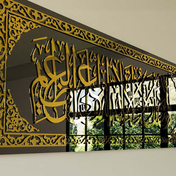 Close-up of gold acrylic calligraphy and border pattern on the black glass wall art, reflecting a window