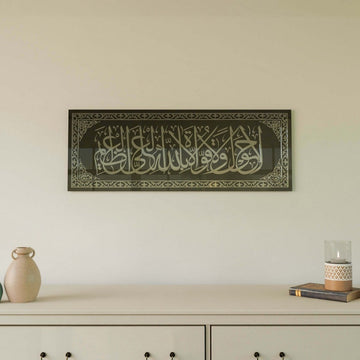 Silver acrylic La hawla wa la quwwata illa billah glass wall art on black glass above a cream console