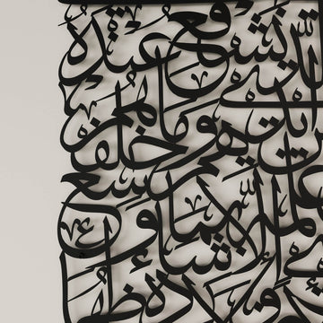 لقطة مقربة لخط آية الكرسي أسود المقطوع من المعدن على جدار فاتح