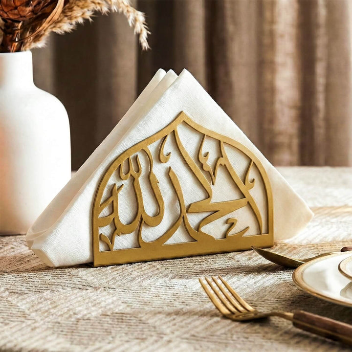 Decorative napkin holder with Arabic calligraphy on a wooden table.