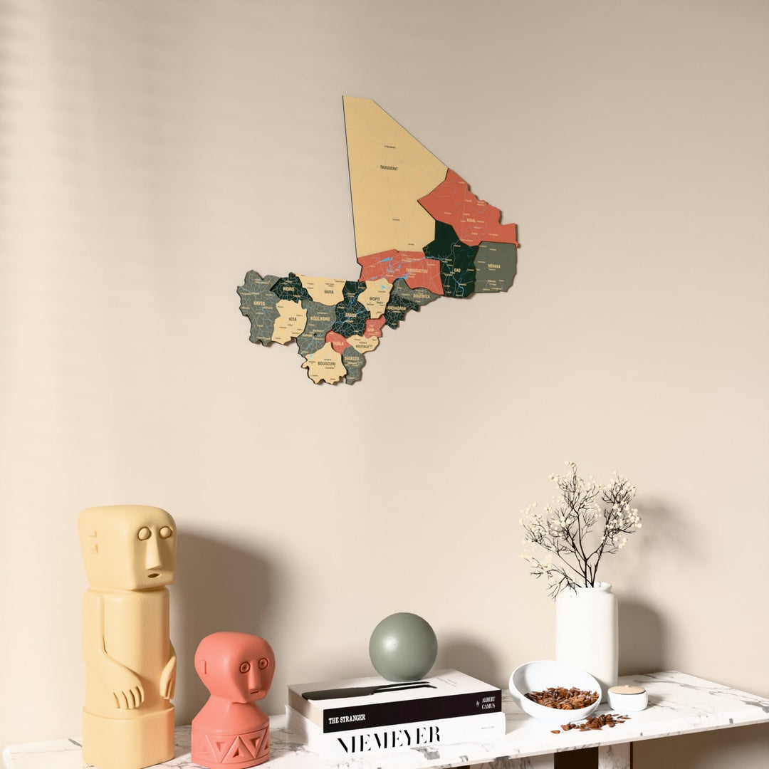 Sage Mali wooden wall map on a beige wall above a console with figurines
