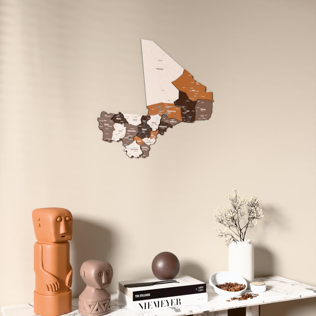Soil Mali wooden wall map on a beige wall above a console with figurines