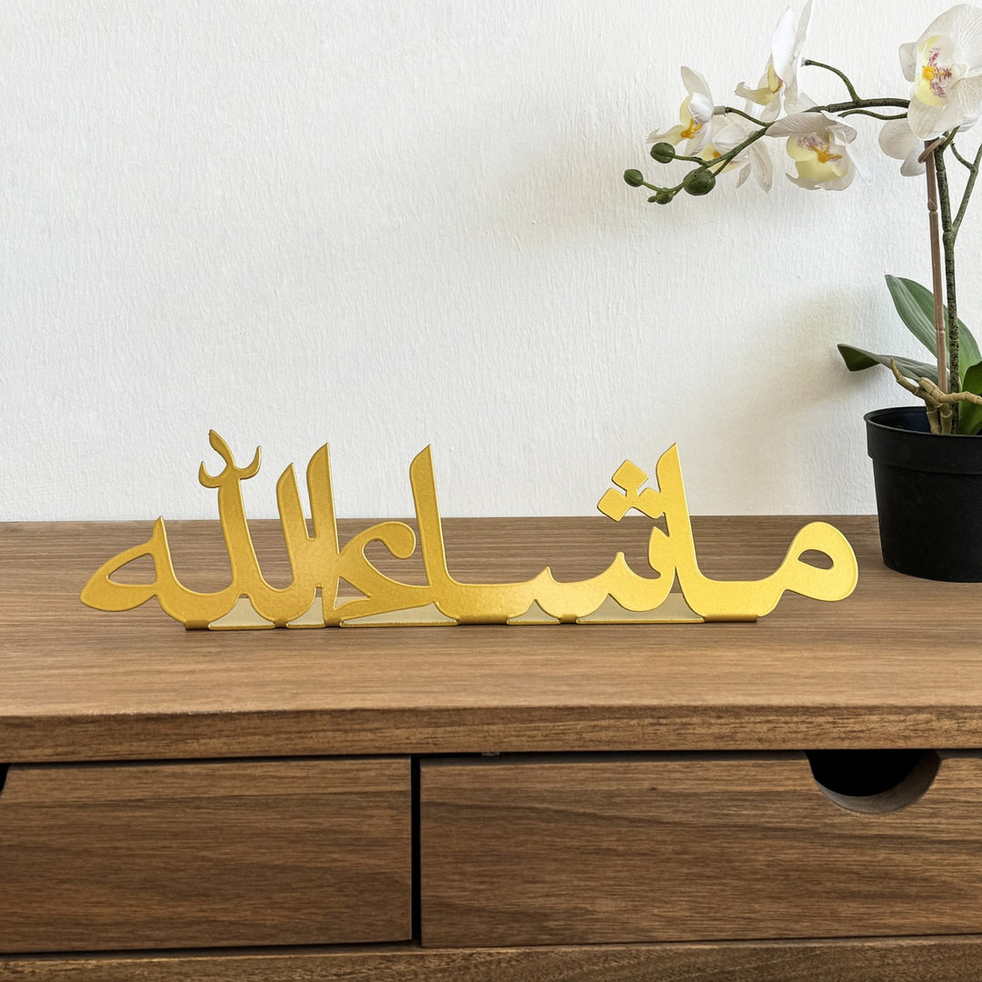 ديكور طاولة معدني ذهبي «ما شاء الله» على مكتب خشبي، منظر أمامي مع زهرة أوركيد