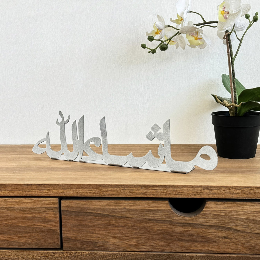 ديكور طاولة معدني فضي «ما شاء الله» على مكتب خشبي، منظر أمامي مع زهرة أوركيد