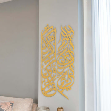 Art mural en métal avec Basmala et sourate Baqarah 152 en doré mat, vue de face à côté d'un voilage