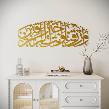 Art mural en métal doré mat Dua pour le rizq au-dessus d'un meuble blanc à portes vitrées arquées