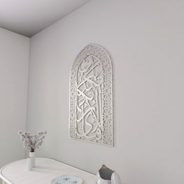 Full silver mihrab Surah Rahman verse 13 metal wall art in a corner above a white table