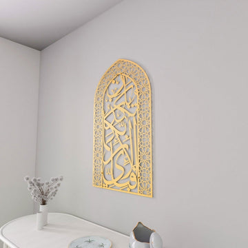 Full gold mihrab Surah Rahman verse 13 metal wall art in a corner above a white table