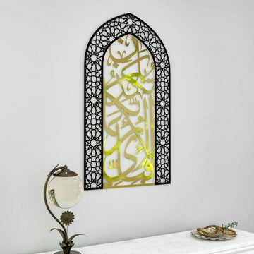 Shiny Gold and black mihrab Surah Rahman verse 13 metal wall art, angled view beside a table lamp