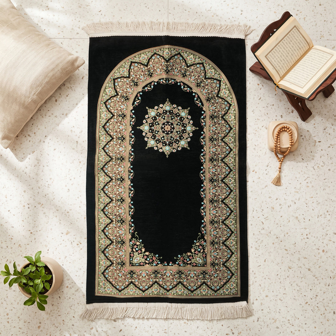 Mihrab Prayer Rug in Black, top view on the floor next to a Quran stand and cushions