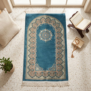 Mihrab Prayer Rug in Petrol Blue, top view on the floor next to a Quran stand and cushions