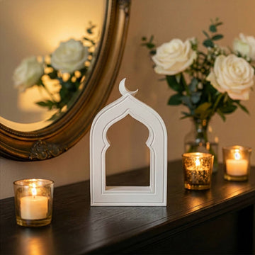 Stone mihrab arch decor front view on a dark shelf with votive candles and white roses