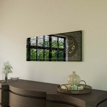 Silver Surah Baqarah 144 glass wall art seen from the side, with a window reflection in the glass