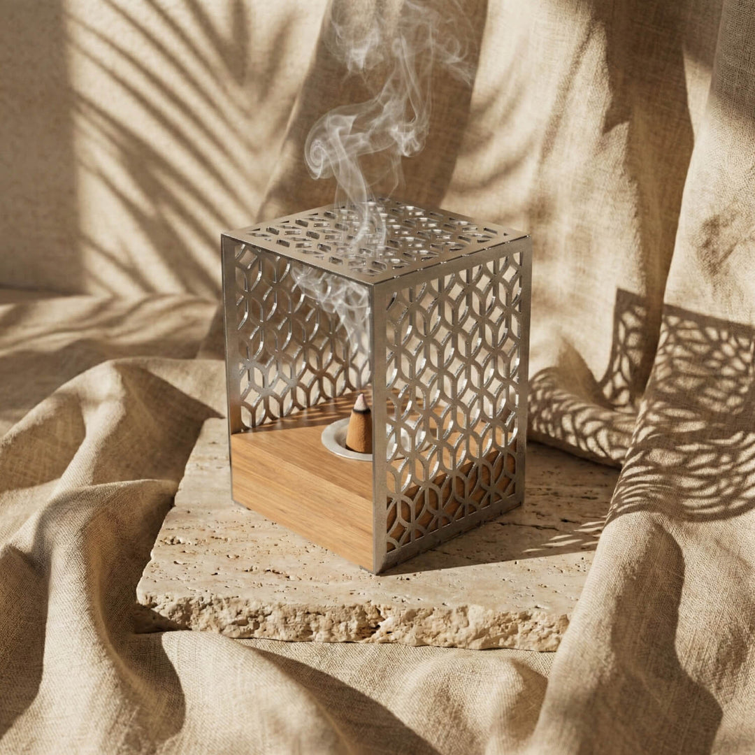 Silver Petal Lattice wooden base mabkhara, angled view showing the incense cone and wooden block