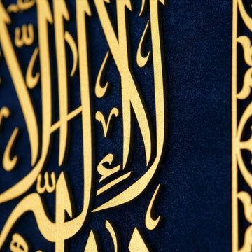 لقطة مقربة جدا لحروف «لا إله إلا الله» الذهبية المقطوعة من الخشب على مخمل أزرق