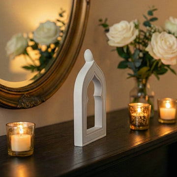 Side profile of the stone mihrab arch showing its slim 3 cm depth beside candles