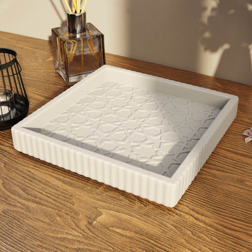 Maurisches geometrisches Steinrelief-Tablett auf einem Holztisch neben einem Diffusor mit Stäbchen und einer Laterne