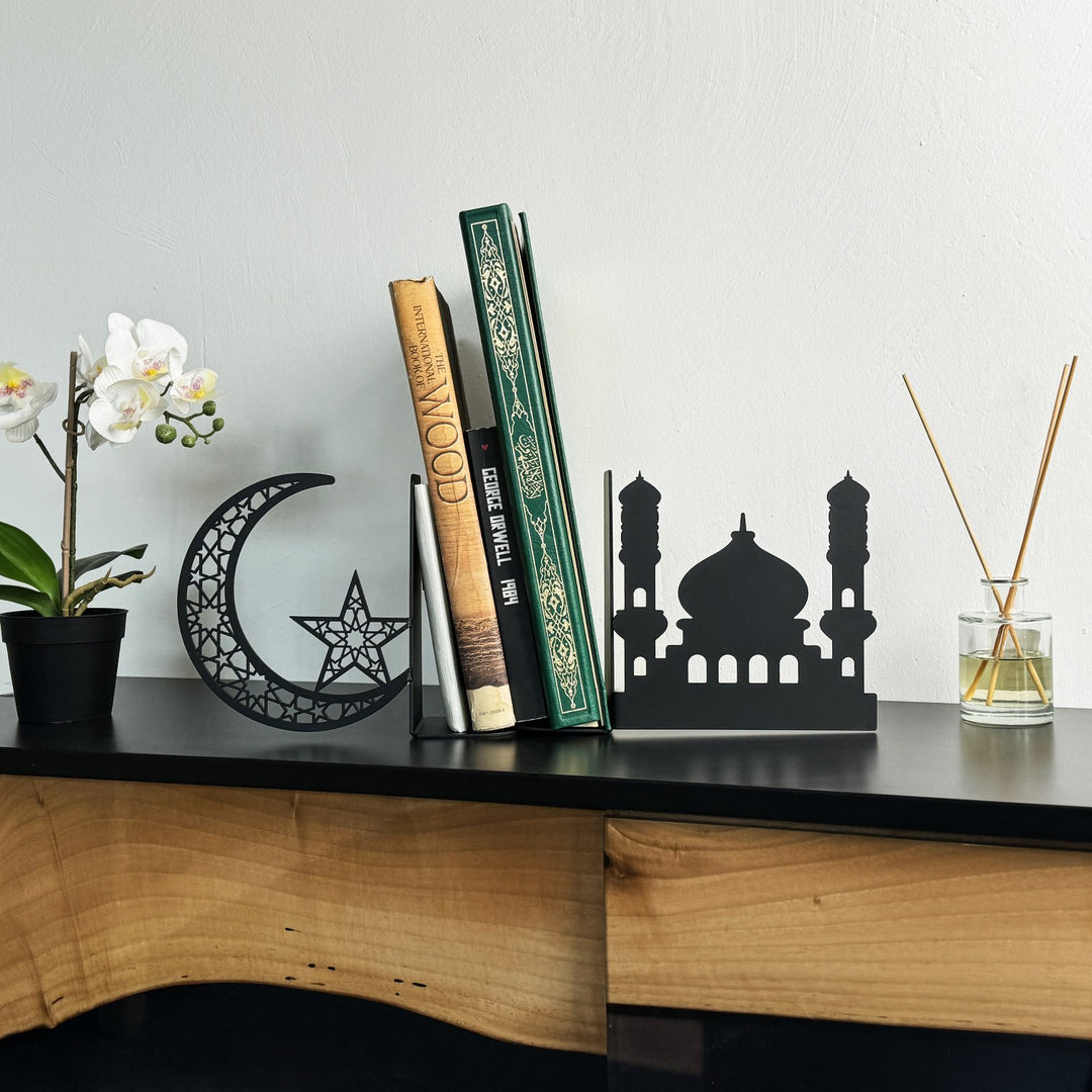 Schwarze Metall-Buchstützen in Moschee- und Halbmondform aus der Ferne auf einer Konsole mit kleiner Orchidee und Diffusor