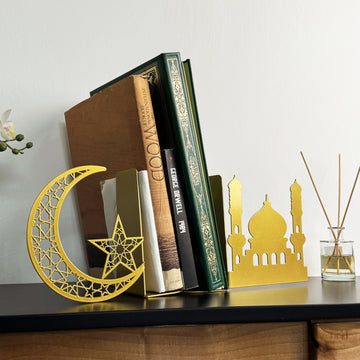 Goldene Metall-Buchstütze mit Halbmond und Stern, schräge Nahansicht mit Büchern und einem Diffusor mit Stäbchen