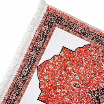 Coin supérieur du tapis de prière rouge et noir montrant la niche blanche et le contour de l'arche