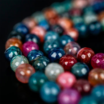 Close-up of faceted multi-colored agate prayer beads in blue, pink and red