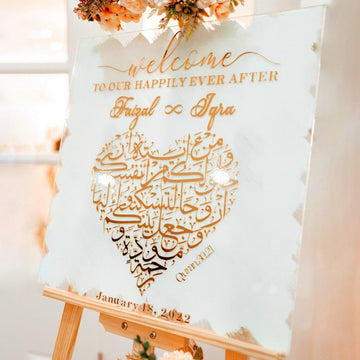 Panneau de bienvenue Nikkah en verre blanc sourate Rum, ayat 21, avec cœur en calligraphie arabe dorée, vue rapprochée en angle
