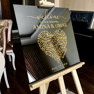 Schräge Ansicht des schwarzen Glas-Nikkah-Schilds Sure Rum 21 auf einer Staffelei mit goldenem Kalligrafie-Herz