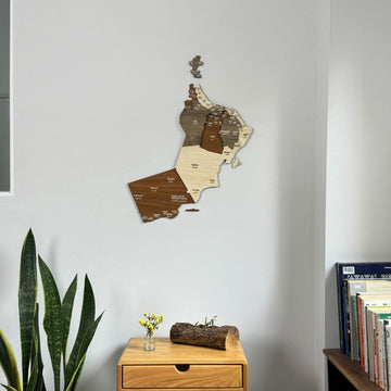 Décoration murale carte d'Oman en bois en vue rapprochée au-dessus d'une table de chevet et d'une bibliothèque