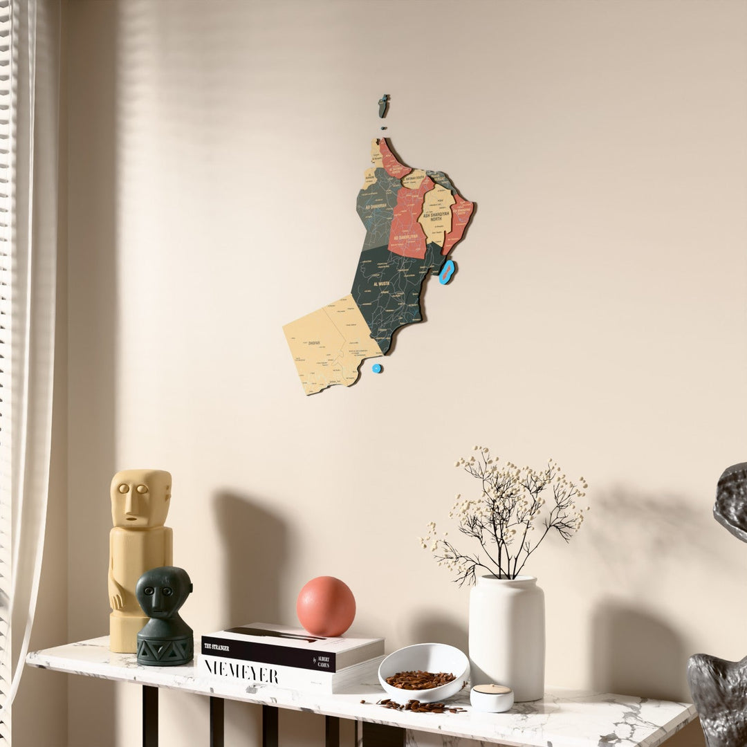 Sage Oman wooden wall map beside a sheer curtain, angled view