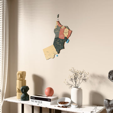 Sage Oman wooden wall map beside a sheer curtain, angled view