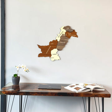 Carte murale du Pakistan en bois fixée au-dessus d'un bureau avec un ordinateur portable et une orchidée