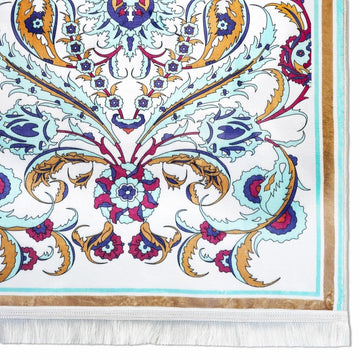Close-up of the pastel floral pattern and bottom fringe of the aqua prayer rug