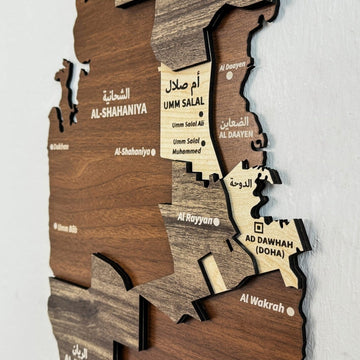 Gros plan de la carte du Qatar en bois avec les noms Umm Salal, Al-Shahaniya et Ad Dawhah (Doha) en anglais et en arabe