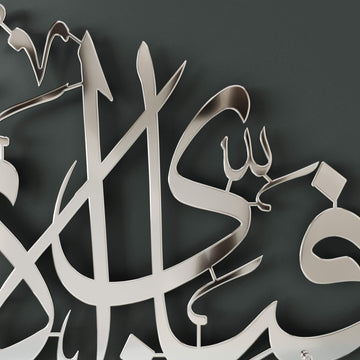 Close-up of Shiny Silver Surah Ar-Rahman calligraphy reflecting the room in the polished metal