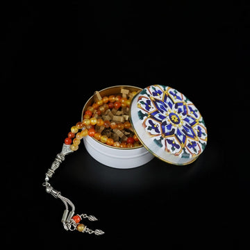 Amber and wood prayer beads with silver tassel in a white tin with blue mandala lid