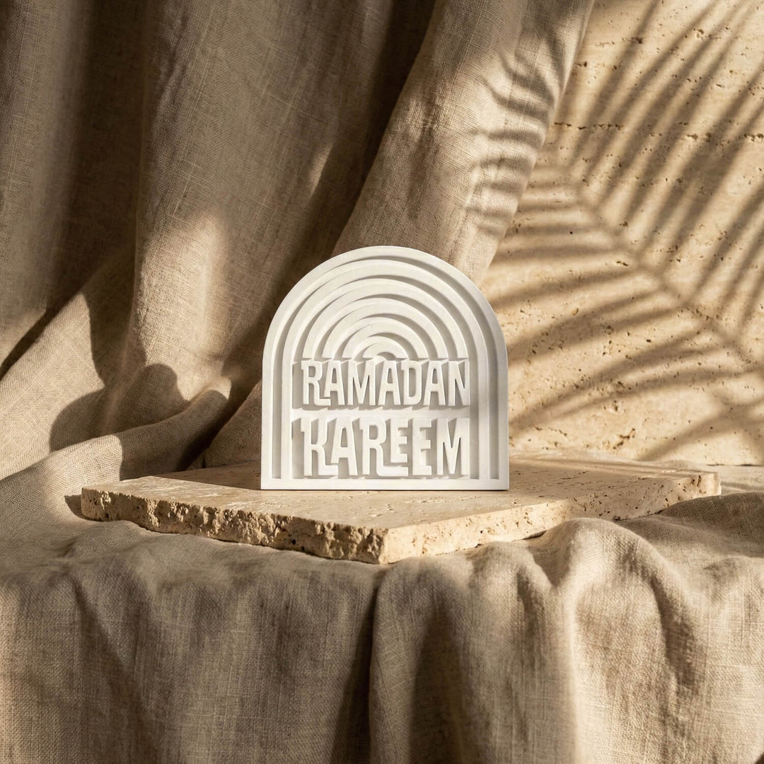 Ramadan Kareem stone arch table decor seen from a distance on a slab over linen