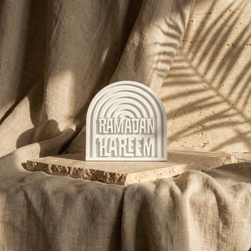 Ramadan Kareem stone arch table decor seen from a distance on a slab over linen