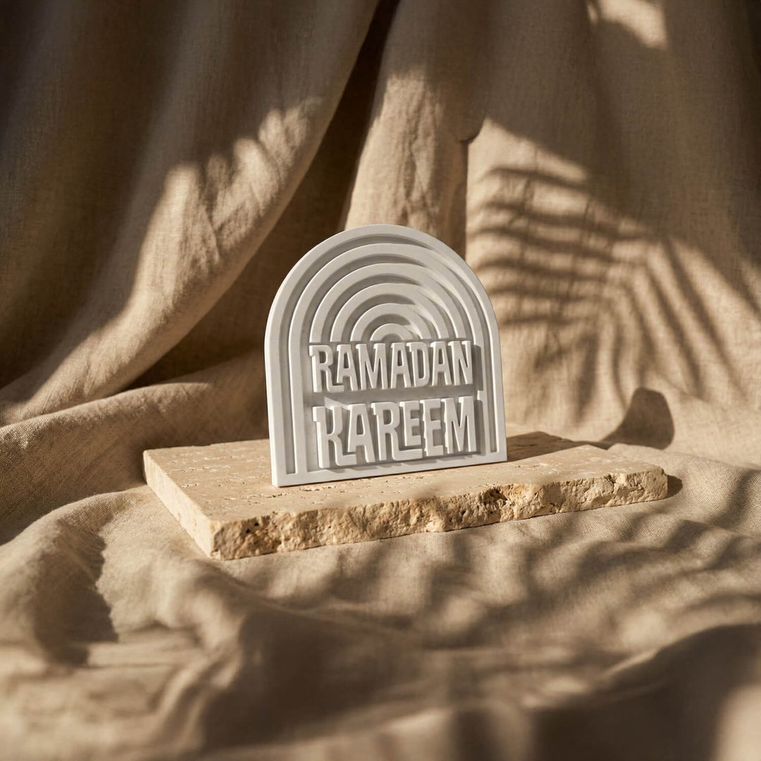 Small Ramadan Kareem stone arch table decor on a stone slab over draped linen