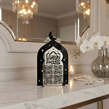 Kufi-Ramadan-Kareem-Acrylaufsteller in Silber auf Schwarz neben einer Gebetskette auf einer Marmorplatte