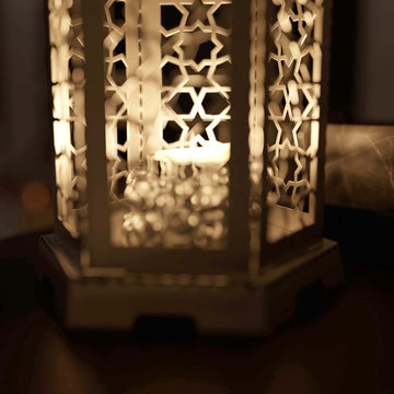 Close-up of the glowing Ramadan lantern panels with star pattern cutouts and a candle