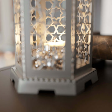 Close-up of the white Ramadan lantern base with geometric cutouts and a candle inside