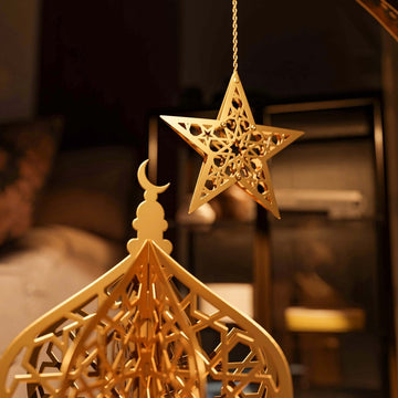 Close-up of the gold lantern dome with a hanging gold star in warm evening light