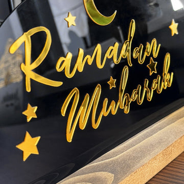 لقطة مقربة لخط «رمضان مبارك» الذهبي والنجوم على اللوح الأكريليك الأسود