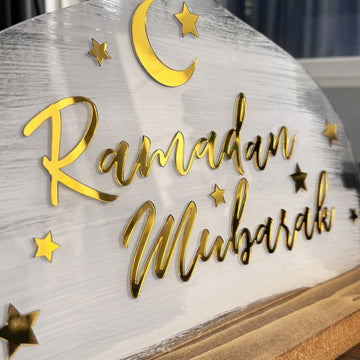 لقطة مقربة لخط «رمضان مبارك» الذهبي المرآة والهلال والنجوم على لوح White Strokes