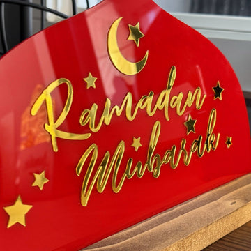 لقطة مقربة لخط «رمضان مبارك» الذهبي والهلال على اللوح الأكريليك الأحمر